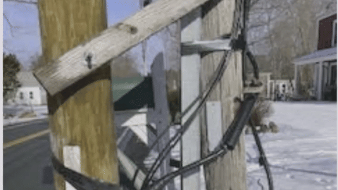 Two utilities poles strapped together and a mess of wires.