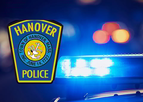 Hanover Police patch in front of flashing police lights.