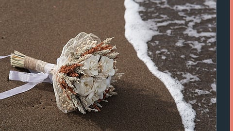 A wedding bouquet of white roses and other white and brown stems tied with a white ribbon lay on the beach. Marshfield Select Board meeting where town property use policies were discussed and postponed due to public concerns.