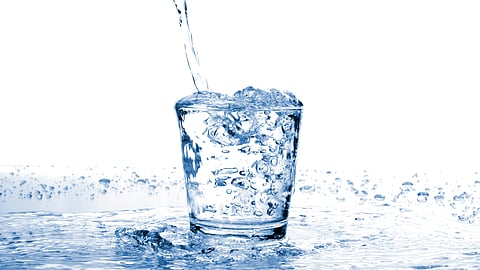 water pouring into a cup and spilling over the sides