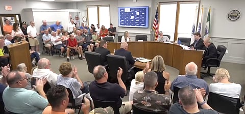A conference room is full of people at a select board meeting