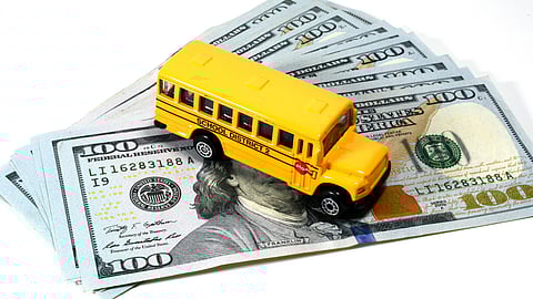 Pile of one hundred dollar bills with a toy school bus on top. Marshfield School Committee hears updates on curriculum plans and federal grant delays for the 2025–26 school year.