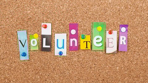 Corkboard with the letters spelling Volunteer pinned to it