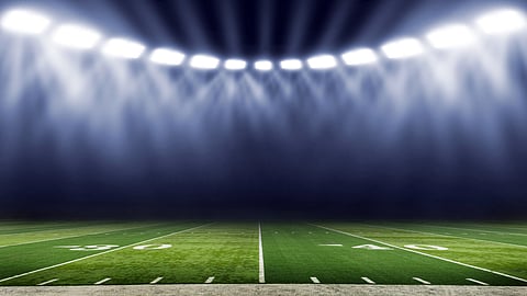 lights on over a football field at night