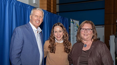 Three professionals pose for a photo