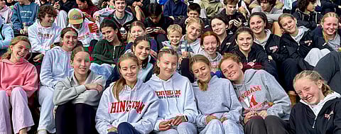Students sit in bleachers to cheer on their fellow runners