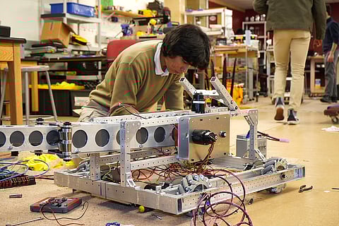 A BC High student works on a robot.