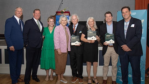 a group of men and women pose with awards