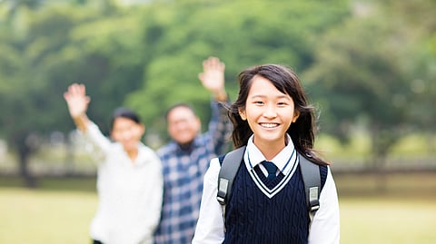 A smiling school girl in a uniform.