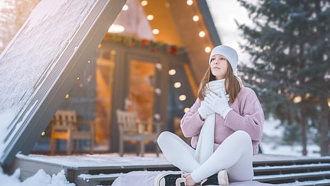 A woman sits cross legged outside in a snowy landscape meditating A holiday wellness gift guide featuring physical therapy tools and movement-friendly stocking stuffers.