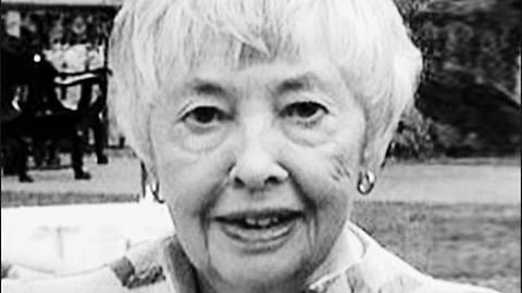 A black and white, shoulders-up image of a woman.