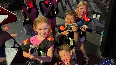a group of elementary school aged kids play laser tag