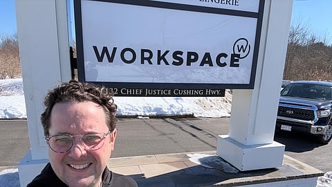 Justin Moran, founder of Workspace, poses in front of new signage.