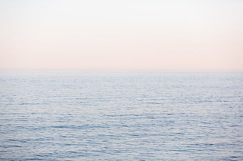 calm blue ocean against a pastel sky