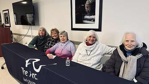 5 women sit at a table with a blue table cloth