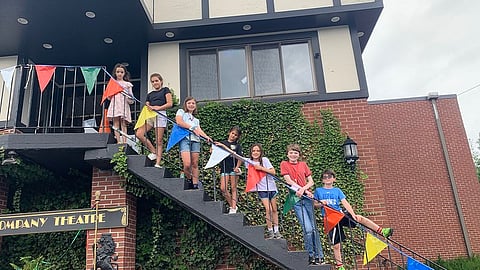 students at theatre camp pose on the stairs to The Company Theatre in Norwell, MA