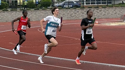 3 track runners race with batons on a red track