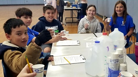 elementary students conduct water experiments at school