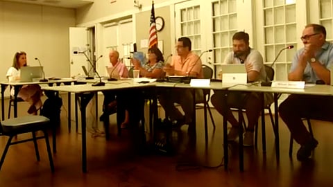 a group of people sit at tables in a room