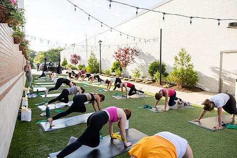 Women in workout wear doing pilates in an open air alleyway
