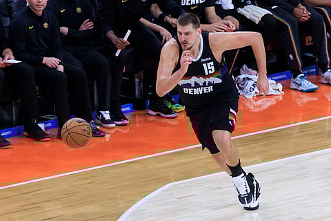 Nikola Jokic dribbles past an opponent