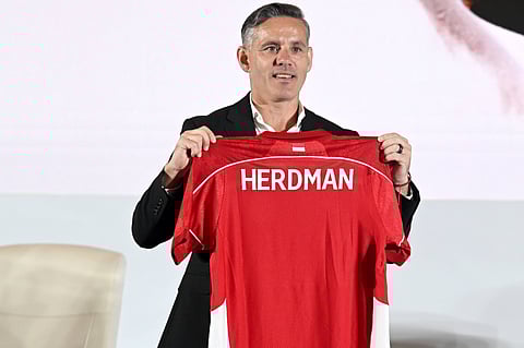 John Herdman holds the Indonesian jersey