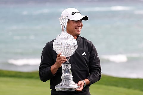 Collin Morikawa poses with the trophy