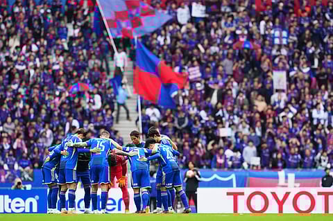 Machida Zelvia players during a team huddle