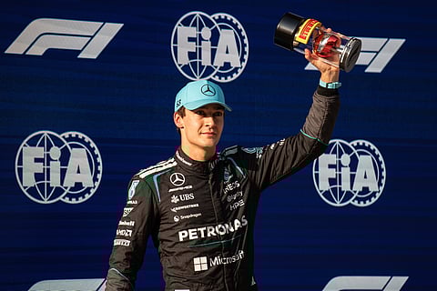 George Russell poses with the trophy