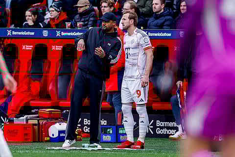 Vincent Kompany discusses with Harry Kane on the touchline