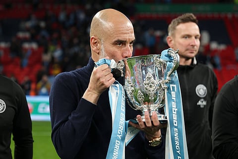 Pep Guardiola kisses the Carabao Cup
