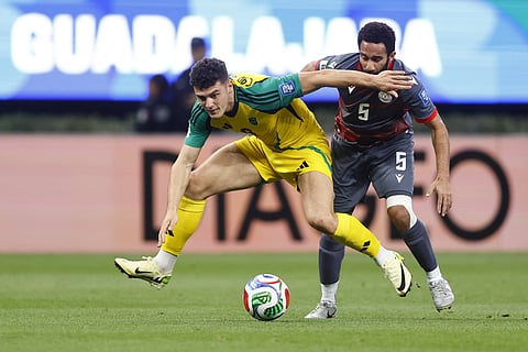 Bailey Cadamarteri of Jamaica fights for the ball against New Caledonia