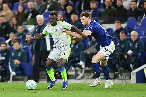 Jeremy Doku and Jake O'Brien compete for the ball