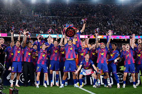 FC Barcelona players lift the La Liga trophy after beating Real Madrid