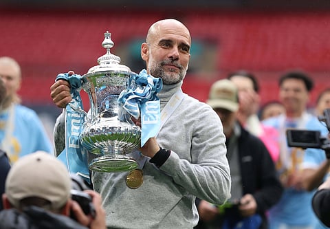Pep Guardiola lifts the FA Cup trophy