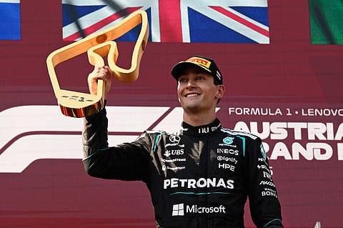 George Russell lifts the trophy on the podium