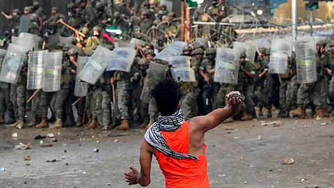 LEBANON. A protester throws a stone toward Lebanese army soldiers during a demonstration, in solidarity with the Palestinian people in Gaza, near the US embassy in Aukar, a northern suburb of Beirut, Lebanon, Wednesday, October 18, 2023.