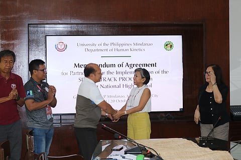 Chancellor Lyre Murao shakes hands with Calinan NHS Principal Edgar Allan Bantigue.