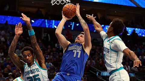 Dallas Mavericks guard Luka Doncic (77) shoots against Charlotte Hornets forward P.J. Washington (25) and guard Theo Maledon, right, in the second half of an NBA basketball game Sunday, Nov. 5, 2023, in Dallas.