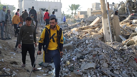 Palestinians look at the destruction by the Israeli bombardment of the Gaza Strip in Rafah, Monday, Dec. 4, 2023.