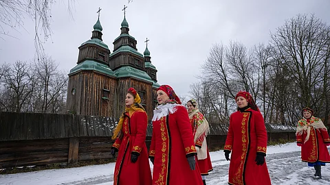 Women dressed in national suits sings carol as they celebrate Christmas in the village of Pirogovo outside capital Kyiv, Ukraine, Monday, December 25, 2023.