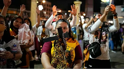 DEBOTO: Usa ka deboto nagbitbit sa gamay nga imahen sa Black Nazarene samtang misalmot sa “Walk of Faith” procession nga kabahin sa kalihukan atol sa kapistahan sa maong patron niadtong Enero 8, 2023, Manila. /