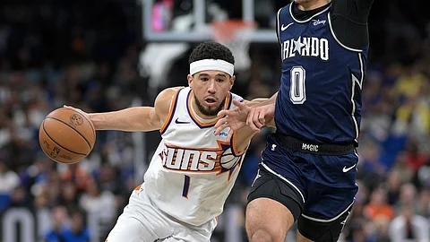 DEPENSA: Nangita’g paagi si Phoenix Suns guard Devin Booker (1) aron lutsan ang pilit nga depensa ni Orlando Magic guard Anthony Black (0) ning aktuha sa usa sa mga aksyon sa NBA kagahapon, Lunes, Enero 29, 2024 (PH time).