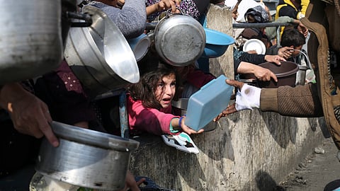 Palestinians line up for free food during the ongoing Israeli air and ground offensive on the Gaza Strip in Rafah, Tuesday, Jan. 9, 2024. /