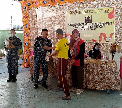 ZAMBOANGA. Superintendent Xavier Solda, Zamboanga City Jail (ZCJ) male dormitory warden (2nd from left), congratulates a person deprived of liberty (PDL) during the first Madrasah graduation inside ZCJ on Friday, January 26. A total of 74 PDLs who are Muslim have completed a seven-month Madrasah study at the BJMP-administered ZCJ in collaboration with the National Commission on Muslim Filipinos.