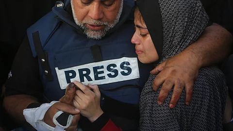 Al Jazeera journalist Wael Dahdouh holds the hand of his son Hamza, who also worked for Al Jazeera and who was killed in an Israeli airstrike in Rafah, Gaza Strip, Sunday, Jan. 7, 2024. Dahdouh lost his wife, two other children and a grandson earlier in the war and was nearly killed himself. / AP