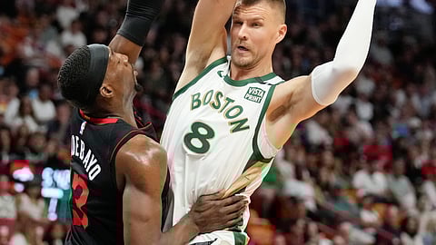 DEPENSA: Nangita og kapasahan sa bola si Boston Celtics center Kristaps Porzingis (8) batok sa pilit nga depensa ni Miami Heat center Bam Adebayo ning aktuha sa usa sa mga aksyon sa NBA ning Lunes, Pebrero 12, 2024 (PH time).