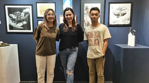 LOCAL ARTISTS. Sabrina Skye Diago Benito (center), owner/manager of Arté Café and Gallery in Dumaguete City, Negros Oriental, with local artists Cil Flores and Wilmer Torres pose in front of some art pieces on Tuesday (Feb. 13, 2024). In celebration of National Arts Month, the gallery is currently holding an ongoing three-week exhibit of more than 50 local artists.