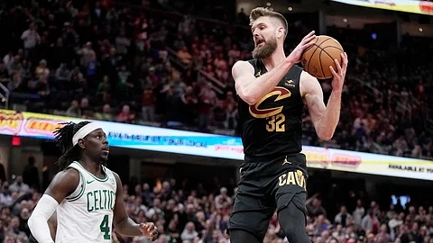 Cleveland Cavaliers forward Dean Wade, right, grabs a rebound in front of Boston Celtics guard Jrue Holiday (4) win the second half of an NBA basketball game, Tuesday, March 5, 2024, in Cleveland.