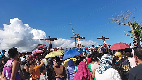 CRUCIFICIED. Gilbert Bargayo, 64, is nailed to the cross at 3 p.m. in Barangay Poblacion 3, Carcar City on Good Friday, March 29, 2024. The two men flanking him, representing the thieves who were crucified with Jesus Christ over 2,000 years ago, are held to the cross only by ropes, rather than nails. / ROLANDO MORALLO